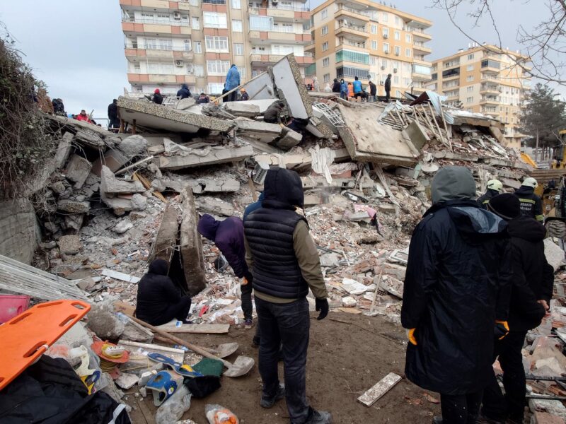 People looking at collapsed buildings in Turkey after the February 2023 earthquake