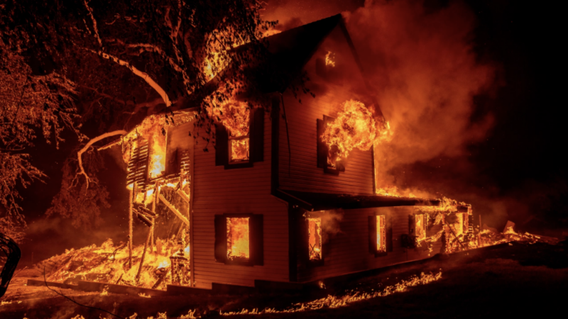 A home burns as the Dixie fire jumps Highway 395 south of Janesville, CA Aug. 16, 2021. (AP Photo/Ethan Swope, File)