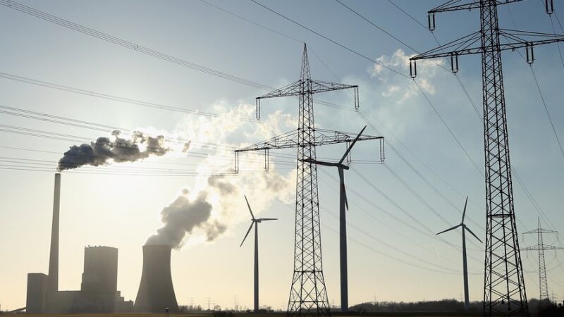 Electric distribution and generation in the foreground with natural gas infrastructure in the background.